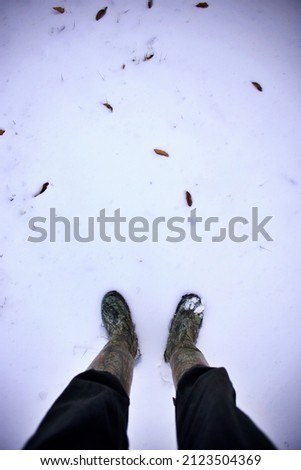 Person standing in the snow with boots on a cold winters day.