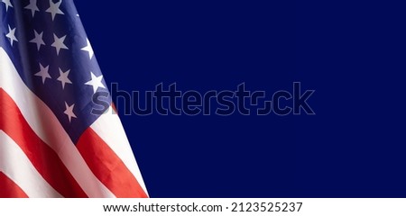 A Close-up of the American flag is on the left side on a blue background with copy space for text. 4th of July. Celebrate American National Day. Labor Day. Independence Day. Memorial Day