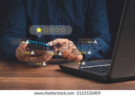Negative feedback concept. Choosing 1-star rating review in the survey, poll, or customer satisfaction research. Bad user experience via a smartphone. Customer experience dissatisfied. Poor rating Royalty-Free Stock Photo #2123526809