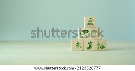 Net zero and carbon neutral concept. Net zero greenhouse gas emissions target. Climate neutral long term strategy. The wooden cubes with green net zero icon and save world icon on grey background. LCA Royalty-Free Stock Photo #2123528777