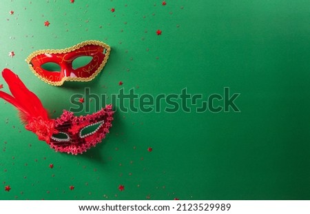 Happy Purim carnival decoration concept made from red mask and sparkle star on green background. (Happy Purim in Hebrew, jewish holiday celebrate).