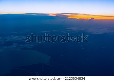 Clouds sunset plane. Aerial view of the orange-blue evening light from the airplane window. Panorama cloud landscape stratosphere. The concept of freedom and independence of travel. Sky background