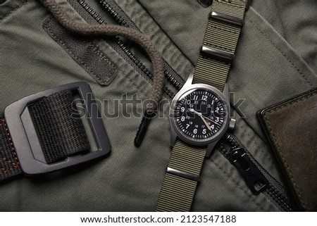 Vintage military watch and leather wallet on army green background, Classic timepiece mechanical wristwatch, Men fashion and accessories. Royalty-Free Stock Photo #2123547188
