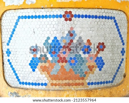 Wall decoration of flowers of many colors made with pieces of earthenware. Geometric texture with flowers on the wall.