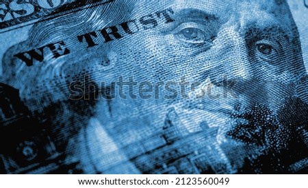 American paper money. A 100 dollar bill with a portrait of Benjamin Franklin in focus. US banknotes close up. Dark blue tinted background about USA dollar. Bonds and treasurys. Macro Royalty-Free Stock Photo #2123560049