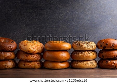 Variety of Different Flavored Bagels on a Dark Wood Table Royalty-Free Stock Photo #2123565116