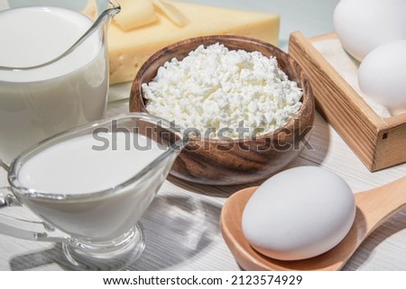 Food is a source of calcium, magnesium, protein, fats, carbohydrates, balanced diet. Dairy products on the table: cottage cheese, sour cream, milk, cheese, chicken egg, contain casein, albumin Royalty-Free Stock Photo #2123574929