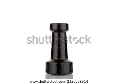 One old wooden chess piece in black, macro, isolated on a white background.