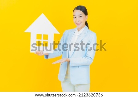 Portrait beautiful young asian woman with house or home paper sign on color background