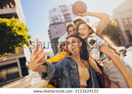 Taking crazy selfies with friends. Group of generation z friends posing for a selfie while hanging out together in the city. Multiethnic young people capturing their fun moments.