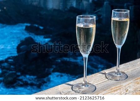New year celebration with two glasses of champagne or Spanish cava sparkling wine and view on black lava rocks, Canary islands, winter tourists destination