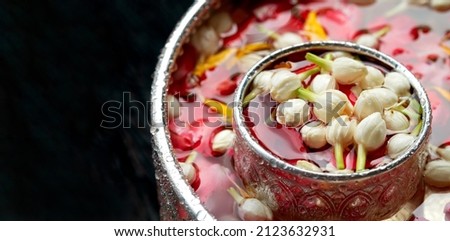 Roses, jasmine and marigolds In a large silver bowl on a wooden floor , Songkran Festival or Thai New Year Royalty-Free Stock Photo #2123632931