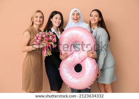 Beautiful women with flowers and balloon in shape of figure 8 on color background. International Women's Day celebration Royalty-Free Stock Photo #2123634332
