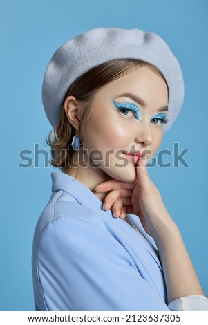 Beauty portrait of a woman with blue eyes, a blue dress and a blue background. Art makeup Professional makeup and cosmetics for the face. Sophisticated art portrait style Royalty-Free Stock Photo #2123637305