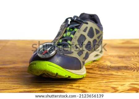 compass on sports shoes concept tourism travel. High quality photo