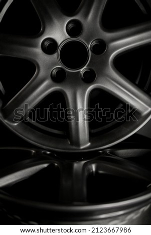 Gray alloy wheel or rim of a car on a black background close-up