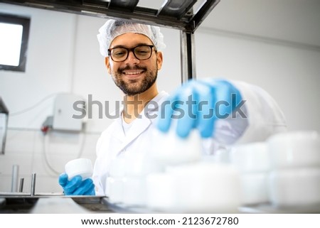 Close up view of pharmaceutical worker technologist working in cosmetics factory with healthcare creme products. Royalty-Free Stock Photo #2123672780