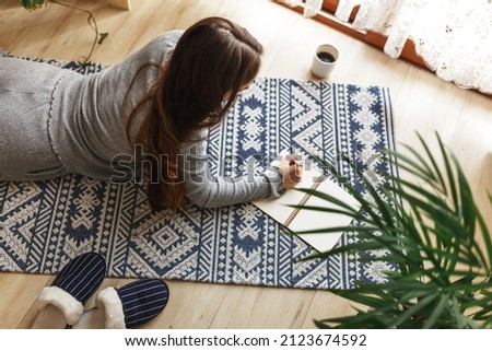 Young woman writing morning pages in diary,planning her business in the morning with notebook and pen in her hands. Drinking coffee Modern bright home interior on background. Royalty-Free Stock Photo #2123674592