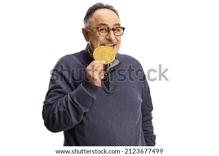 Happy mature man biting a bitcoin isolated on white background Royalty-Free Stock Photo #2123677499
