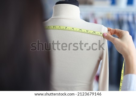 A woman measures the width with a tape on a mannequin Royalty-Free Stock Photo #2123679146