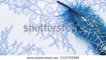 lace fabric. bird feather. blue color on a white background. Delicately crafted from yarn or thread, lace fabrics have historically embodied class and beauty since their inception in the 16th century.
