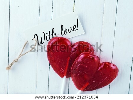Lollipop hearts on white wooden background. 