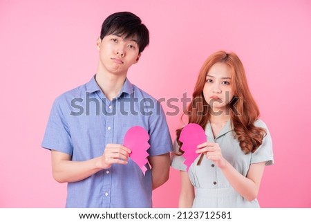 Young Asian couple posing on pink background Royalty-Free Stock Photo #2123712581