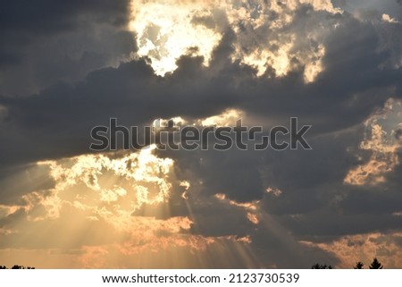 A portrait of an evening cloudscape portraying sun rays through the clouds.