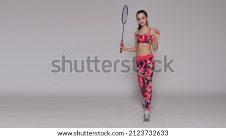 beautiful young girl holding badminton racket over white background