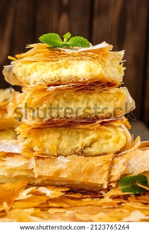 Filo pastry layer cake with custard filling. Freshly baked filo pastry with cream. Vertical photo, close-up.