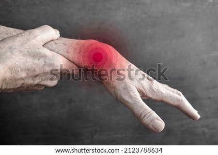 Pain in the wrist joint of Southeast Asian elder man. Concept of hand pain, rheumatoid arthritis, rheumatism and arm problems.
