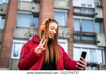 young girl takes a photo of herself in the town square