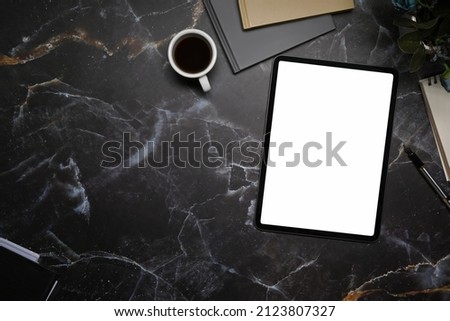 Digital tablet, notepad and coffee cup on marble background. Top view .