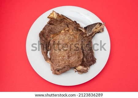 grilled fresh meat on big gray dish on red paper