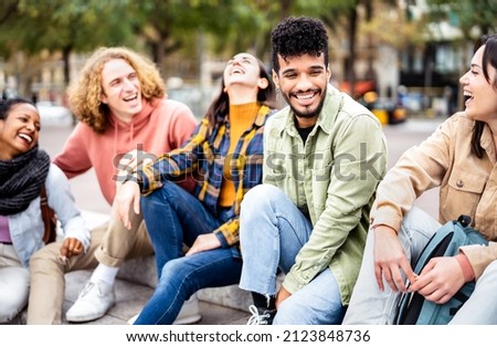 Milenial friends sitting together at city center on life style concept - Happy guys and girls having fun talking around Barcelona street - University students on travel vacation  - Bright vivid filter Royalty-Free Stock Photo #2123848736