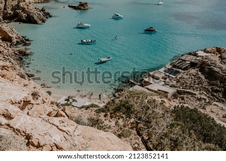 A tranquil scene of beautiful landscape in Ibiza overlooking turquoise waters and white sand beach. 
