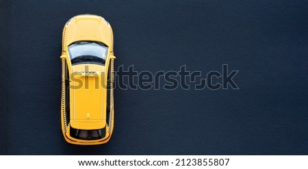 Yellow taxi car top view on a black background macro photography. Taxi service advertising banner. Car rental concept.