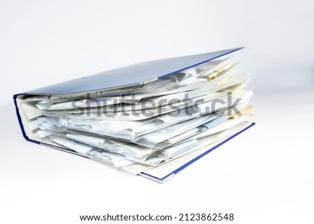 Large ring binder with clear punched pockets full of receipts, office management, accounting and tax calculation, light gray background, copy space, selected focus, narrow depth of field Royalty-Free Stock Photo #2123862548