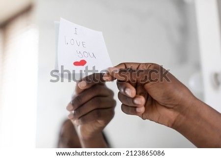 Black Female Hand Putting Sticky Note With Love Message On Mirror, Closeup Shot Of Unrecognizable African American Woman Sticking Paper With I Love You Text And Drawn Heart, Cropped Image