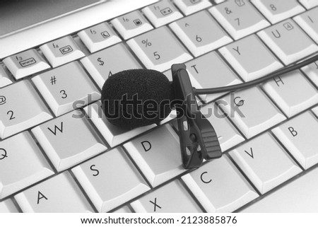 Lavalier microphone on laptop keyboard close up. Blogging and internet streaming concept.