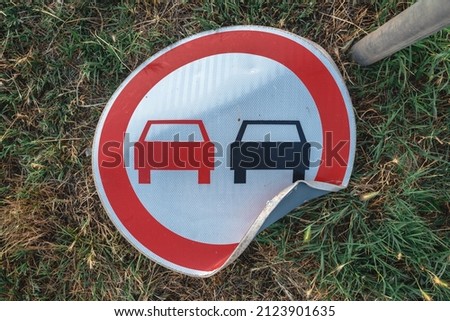 No overtaking traffic sign knocked on the ground, top view