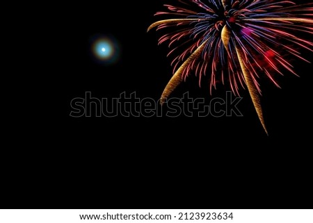 ULSTEINVIK, NORWAY- DECEMBER 31. Colorful firework with full moon next to it.