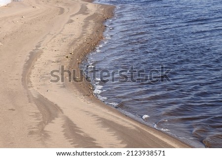 nature in winter on the banks of the Volga, ice with sand and snow, river sandy background