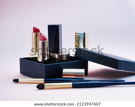 set of cosmetics for a female face and eye makeup in a black craft box on a pink background. photo