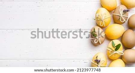 Festive Easter background. Easter eggs with flowers on a white table. Flat lay, place for text.