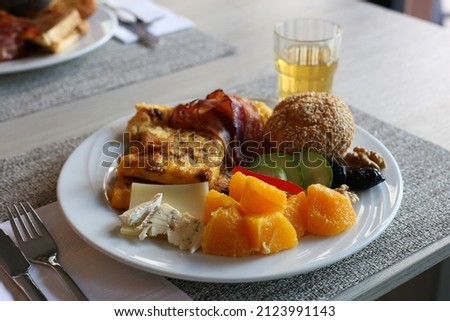 Delicious hotel breakfast in Switzerland, Europe. Plate of different baked goods like bread, veggies, omelettes, meats and more. Closeup color image. Fresh start for the holiday morning in Europe!