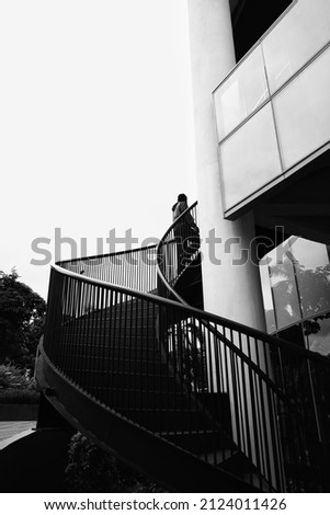 Back view of businessman walking up staircase. Back to office or climbing up the corporate ladder concept Black and white photography concept