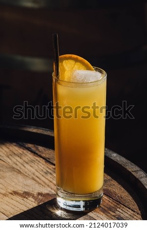 orange juice drink with straw, ice, and orange slice Royalty-Free Stock Photo #2124017039