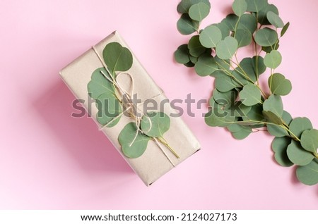 Gift box wrapped in brown paper decorated with eucalyptus branch, natural eco friendly zero waste gift wrapping idea. Top view.