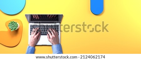 Person using a laptop computer with geometric shaped objects from above